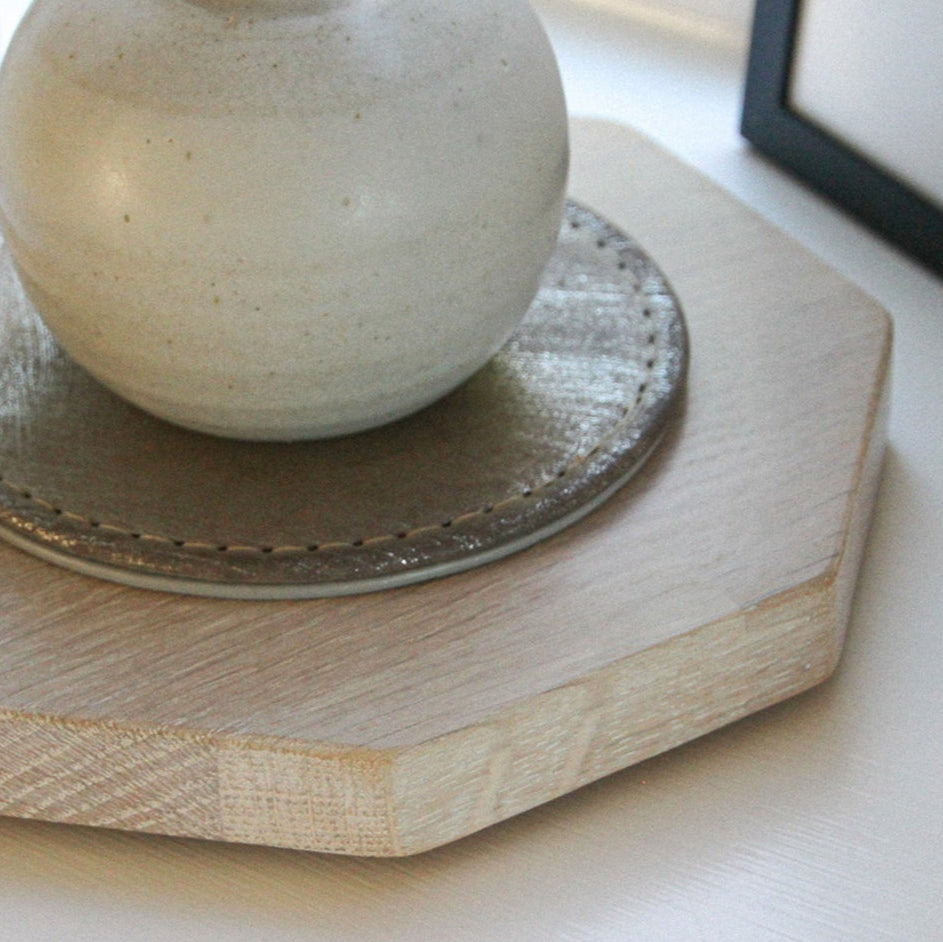 Ceramic bowl on a textured coaster with a wooden block in limed oak, this shot is close up to the 50 pence piece shaped mat