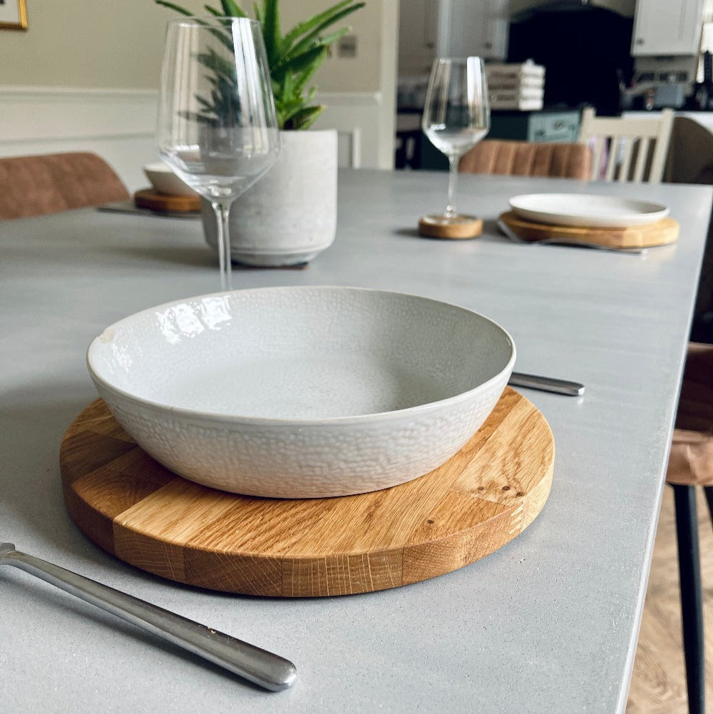 round oak dining set with a pottery bowl on a micro cement dining table