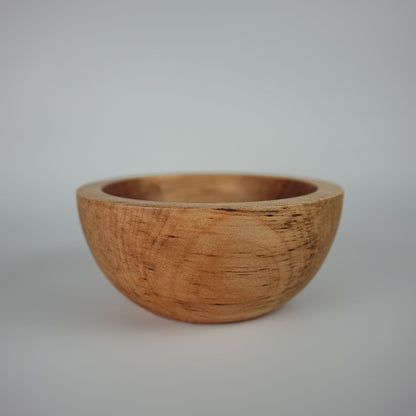 Decorative bowl made from sycamore wood on a plain white background