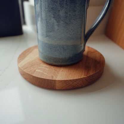 Blue mug on a large wooden mat on a white surface