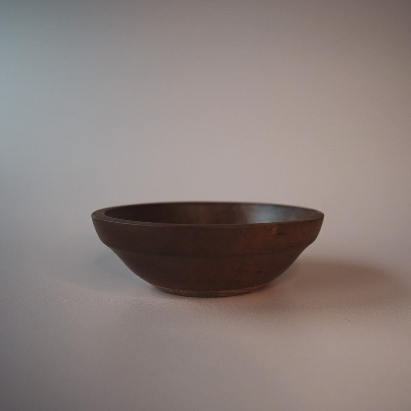 dark apple wood bowl on an plain background