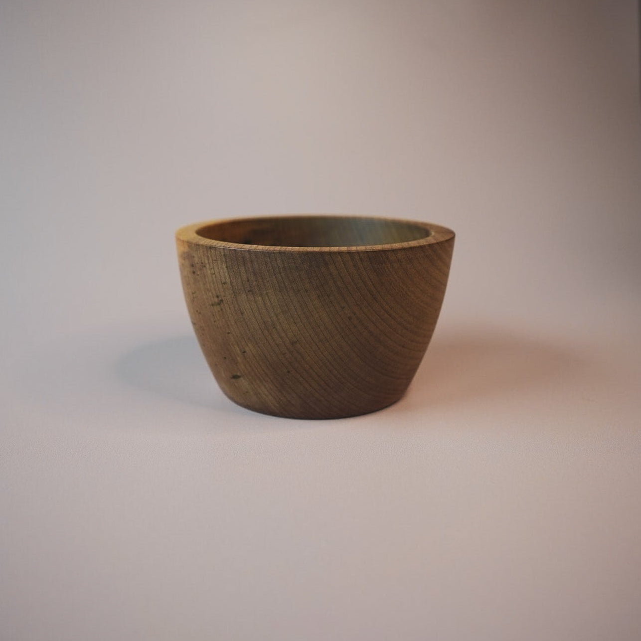 Dark wooden bowl on a plain background